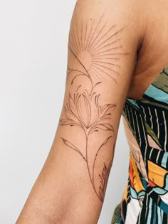 a woman's arm with a tattoo on it that has a flower in the center