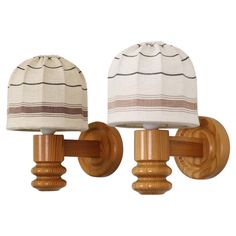 two wooden sconces with white and brown lamps on each side, one has a striped lamp shade