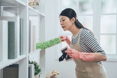 a woman in an apron is using a green brush