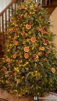 a christmas tree decorated with oranges and greenery