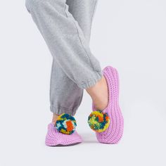 Our classic indoor knit slippers topped with a brightly colored 3" pompom. Plush and padded with the softness and cozy fit of your favorite socks. Fleece-lined with a wide toe box, stretchy knit body, and microfiber sole with slip-resistant patches. Made with deadstock yarn. Washable. Seamlessly knit for less material waste—part of our mission to make happy knits that send less to landfills. Sizes: S/M (Womens 6-8) M/L (Womens 8-10) Knit slippers have sock-like fit and will feel snug when new bu Casual Winter Yarn Slippers, Casual Knitted Yarn Slippers, Bar Apron, Knit Slippers, Hair Necklace, Candle Wrap, Cocktail Book, Back Bag, Print Calendar