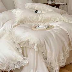 a bed with white comforters and pillows on it