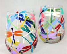 two wine glasses with dragonflies painted on them