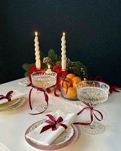 a table set for christmas with candles and fruit