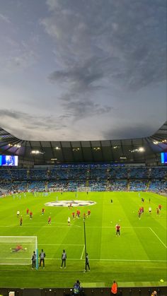 a large soccer field with many people on it and the sky in the back ground