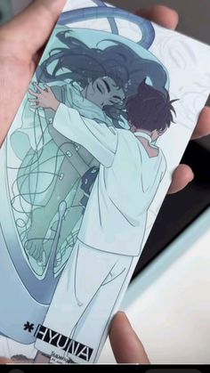 someone holding up a card with an image of two people hugging