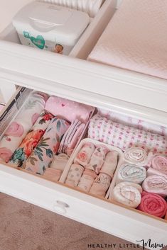 an open drawer filled with baby blankets and diapers