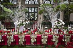 the tables are set up with red and white linens for an elegant wedding reception