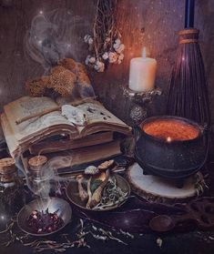 an open book sitting on top of a table next to other items and candles in bowls