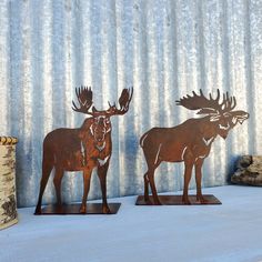 two metal moose sculptures sitting next to each other