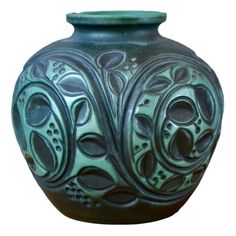 a green vase with intricate designs on it