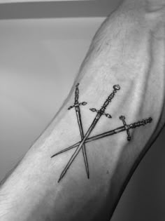 a man's arm with two crossed swords on it