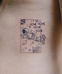 a man's chest with an astronaut tattoo on his left side ribcage