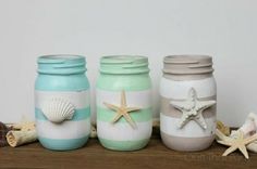 three jars with starfish and seashells painted on them sitting on a shelf