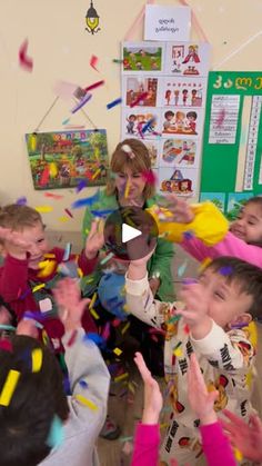 a group of children standing around each other with confetti in front of them