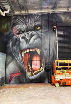 a large painting of a gorilla on the side of a building with it's mouth open