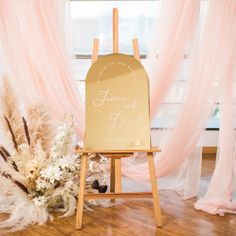 a wooden easer with a sign on it next to some flowers and other decorations