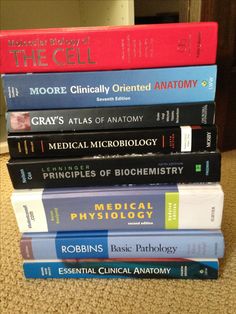 a stack of books sitting on top of a carpeted floor next to each other