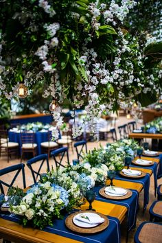 tables set up with blue and yellow linens for an outdoor wedding reception in the garden