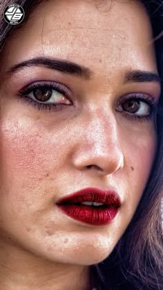 a close up of a woman with dark hair and red lipstick on her face, looking at the camera