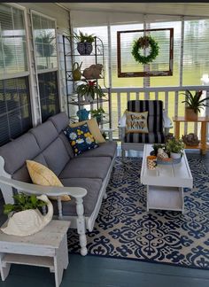 the porch is decorated with white furniture and potted plants