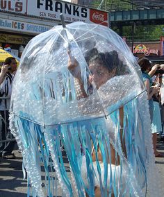 a woman is dressed up as a jellyfish under an umbrella