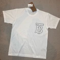 Burberry Monogram Motif Short-Sleeve T-Shirt Color : White Size Xxs Big Tb Logo Made In Italy Cotton Blend Measurements: Pit To Pit 20 Inches Shoulder To Shoulder : 18 Inches Item Is In Perfect Condition, Has A Small Stain In The Inside White Burberry Tag. Streetwear Monogram Print Short Sleeve T-shirt, Short Sleeve Monogram Print T-shirt For Streetwear, Summer Graphic Tee With Logo Detail, Monogram Print Short Sleeve T-shirt For Streetwear, Monogram Print Graphic Tee For Streetwear, Graphic Tee With Monogram Print And Short Sleeves, White Logo Detail Short Sleeve Tops, White Monogram Print Graphic Tee, White Short Sleeve Top With Logo Detail