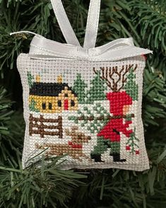 a cross stitch ornament hanging from a christmas tree