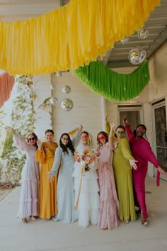 a group of women standing next to each other in front of a building with decorations