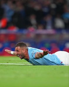 a soccer player laying on the ground with his mouth open