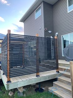 a wooden deck in front of a house with metal slats on the railings