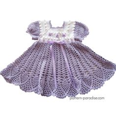 a crocheted baby dress with white and purple trimmings on the collar