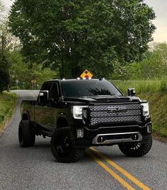 a black truck is driving down the road