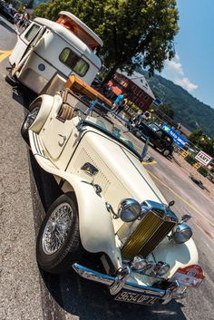 an old car is parked on the side of the road