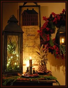 a table topped with two lit candles next to a christmas wreath and pine cone wreath