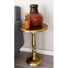 a small table with a vase on it and a flower pot sitting on top of it