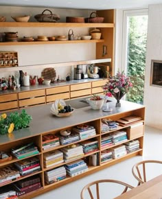 a kitchen filled with lots of wooden furniture and shelves next to a fire place covered in pots and pans