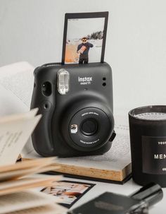 a camera sitting on top of a table next to a book and cup filled with coffee