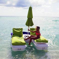 a woman sitting on an inflatable lounge chair at the beach