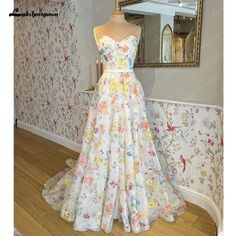 a dress on display in front of a wallpapered room with flowers and birds