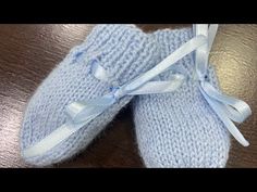 a pair of blue knitted slippers on top of a wooden table