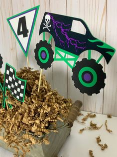 a monster truck birthday cake topper sitting in a pile of wood shavings