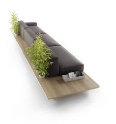 a couch sitting on top of a wooden table next to a planter filled with plants