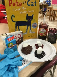 there is a plate with cake and ice cream on it next to a book about pete the cat