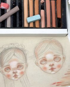 two children's drawings and crayons are shown in this box with pencils