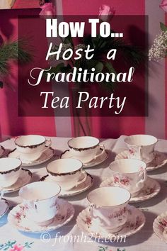 a table topped with lots of tea cups and saucers next to a vase filled with pink roses