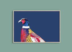 a colorful bird on a blue background in a wooden frame hanging on the wall above it