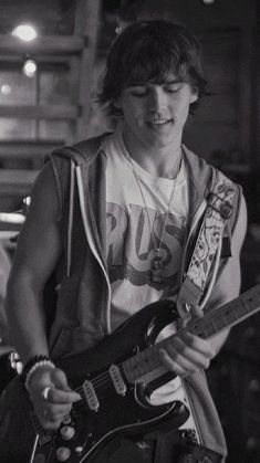 black and white photograph of a young man playing an electric guitar