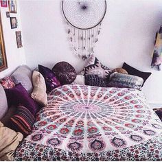 a bed with pillows and blankets on it in a room that is decorated with pictures