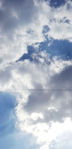 an airplane is flying through the cloudy sky